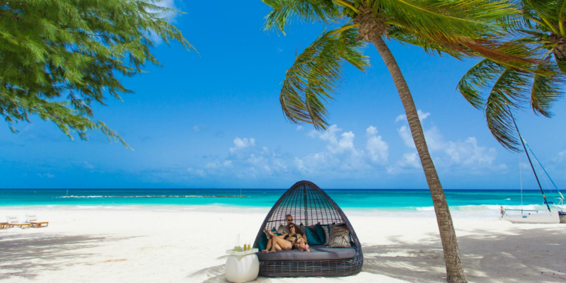 People relaxing in a chair on Maxwell Beach, Barbados