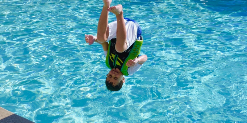 Boy jumping into a pool