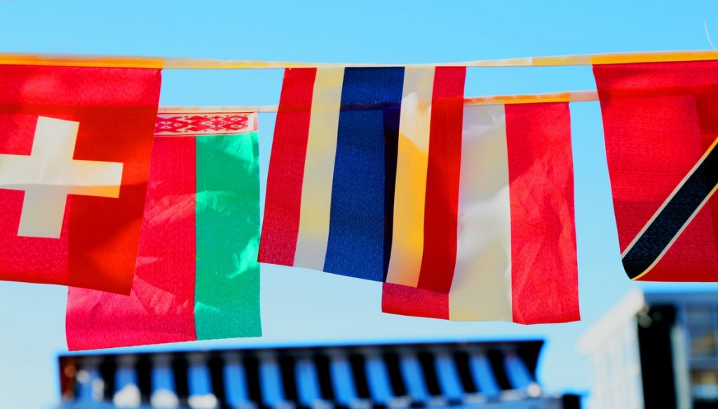 coloured flags hang on a row outside