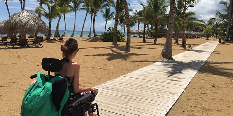 Wheelchair user on the accessible beachfront boardwalk at Excellence el Carmen
