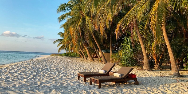 Two sun loungers next to each other on a tropical beach