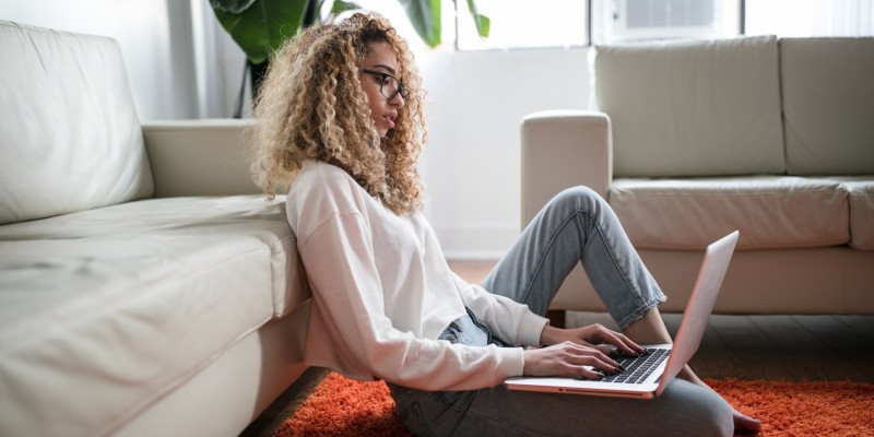 Woman working on a laptop in a lounge area