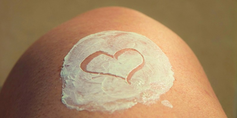 heart drawn into sun cream on skin
