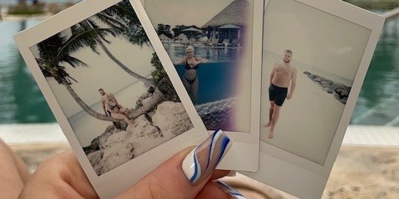Woman holding polaroid pictures of holiday