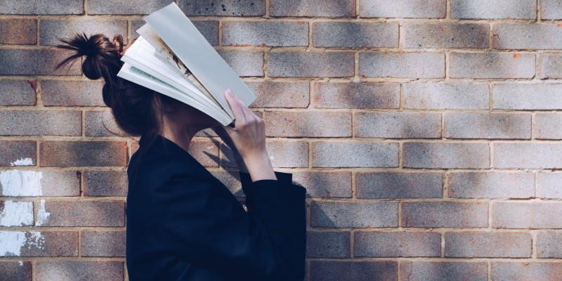 woman with her head in a book