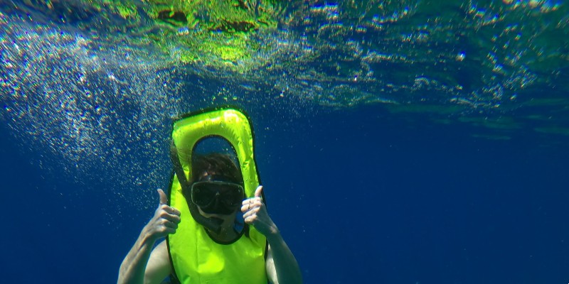 Woman snorkelling and putting her thumbs up to the camera