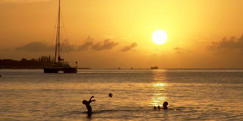 Two children playing in the Sea at sunset in Jamaica