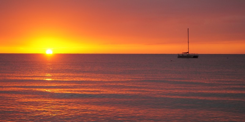 A boat on the horizon at sunset in the Caribbean