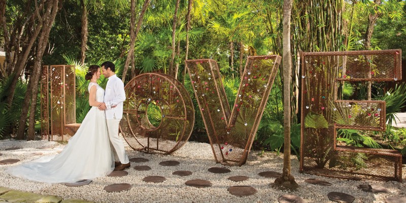 Couple getting married in front of a large LOVE sign