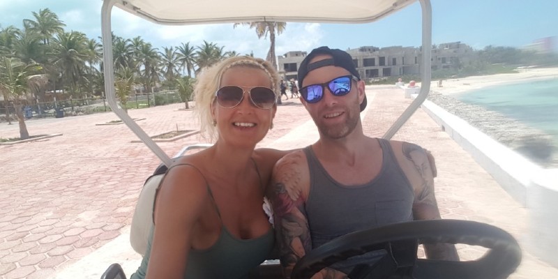 Man and woman exploring Mexico in a golf cart